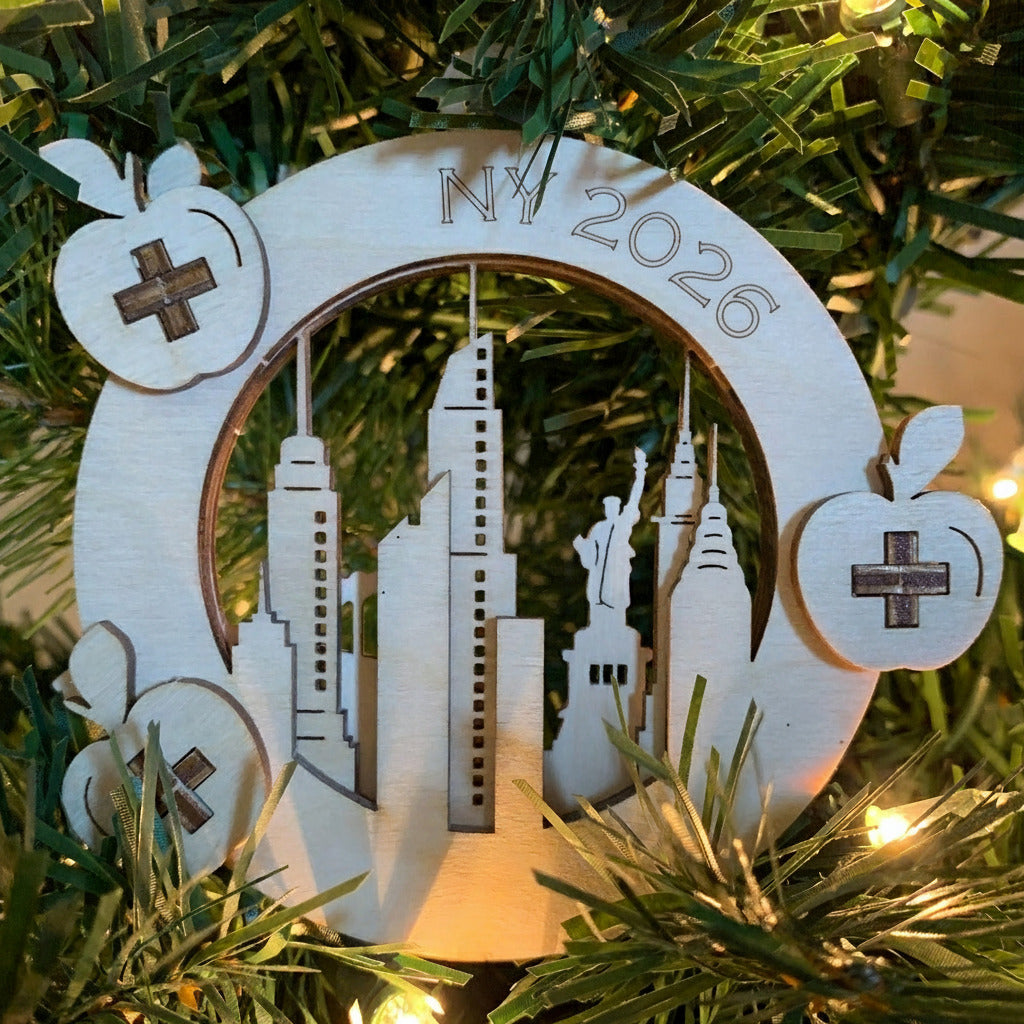 Laser cut ornament positioned in a tree - the ornament is made of 3 layers depicting a NYC skyline 
