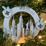 Laser cut ornament positioned in a tree - the ornament is made of 3 layers depicting a NYC skyline 