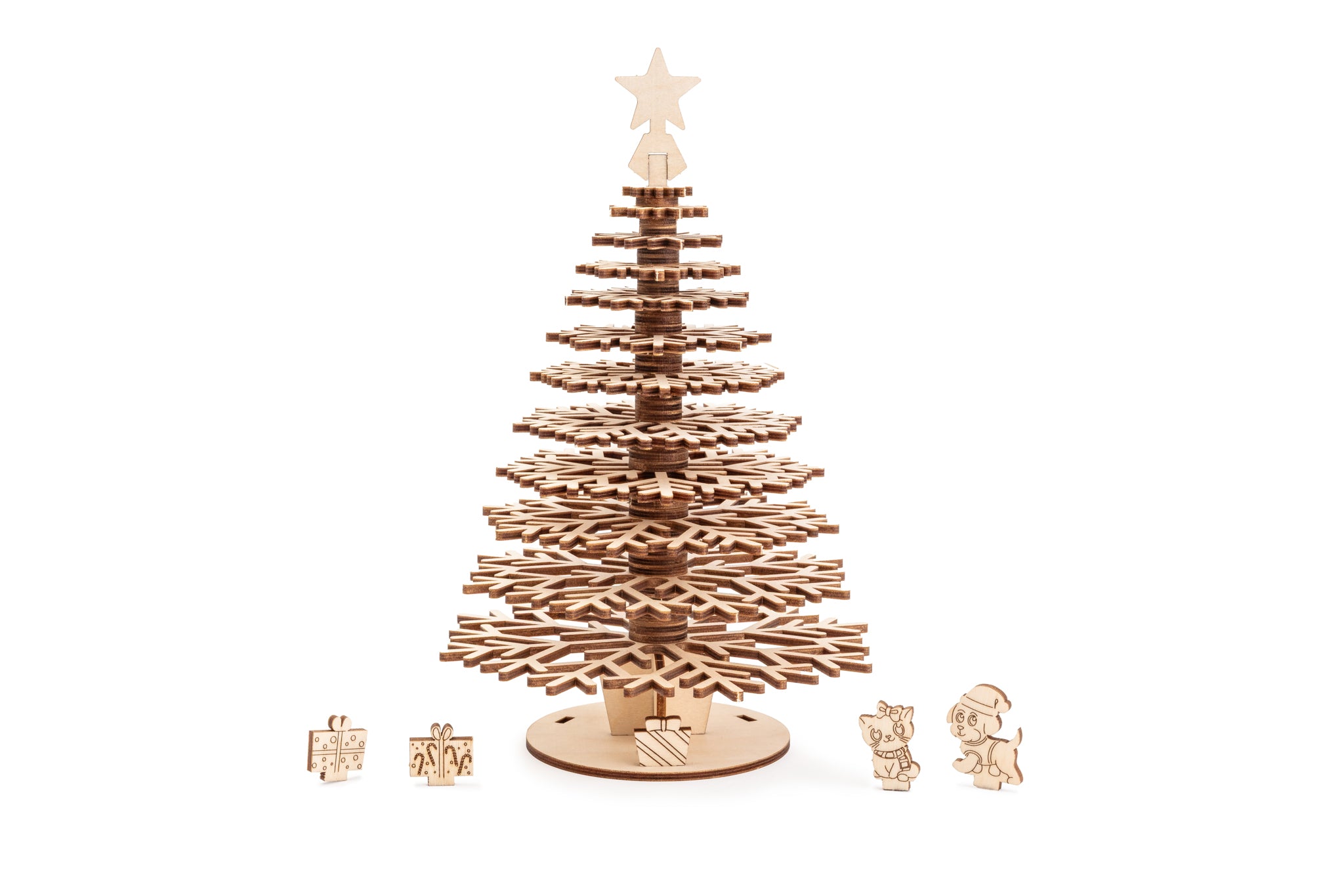 A single laser-cut wooden Christmas tree with tiered snowflake branches, featuring a white star finial topper and miniature colorful gift box and a cat and dog accents at the base.