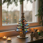 Wooden Christmas tree with decorative figures and lights on a windowframe