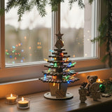 Wooden Christmas tree with decorative figures and lights on a windowframe