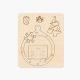 Wooden plate showing laser cut  with Christmas-themed cutouts on a beige background