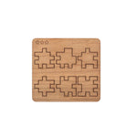 Laser-cut wooden pieces and components of the CubeMaster Pro 3D cube puzzle shown on board