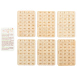 A set of six binary magic cards featuring grids of numbers laid out next to a printed instruction sheet for the mathematical number-guessing game.
