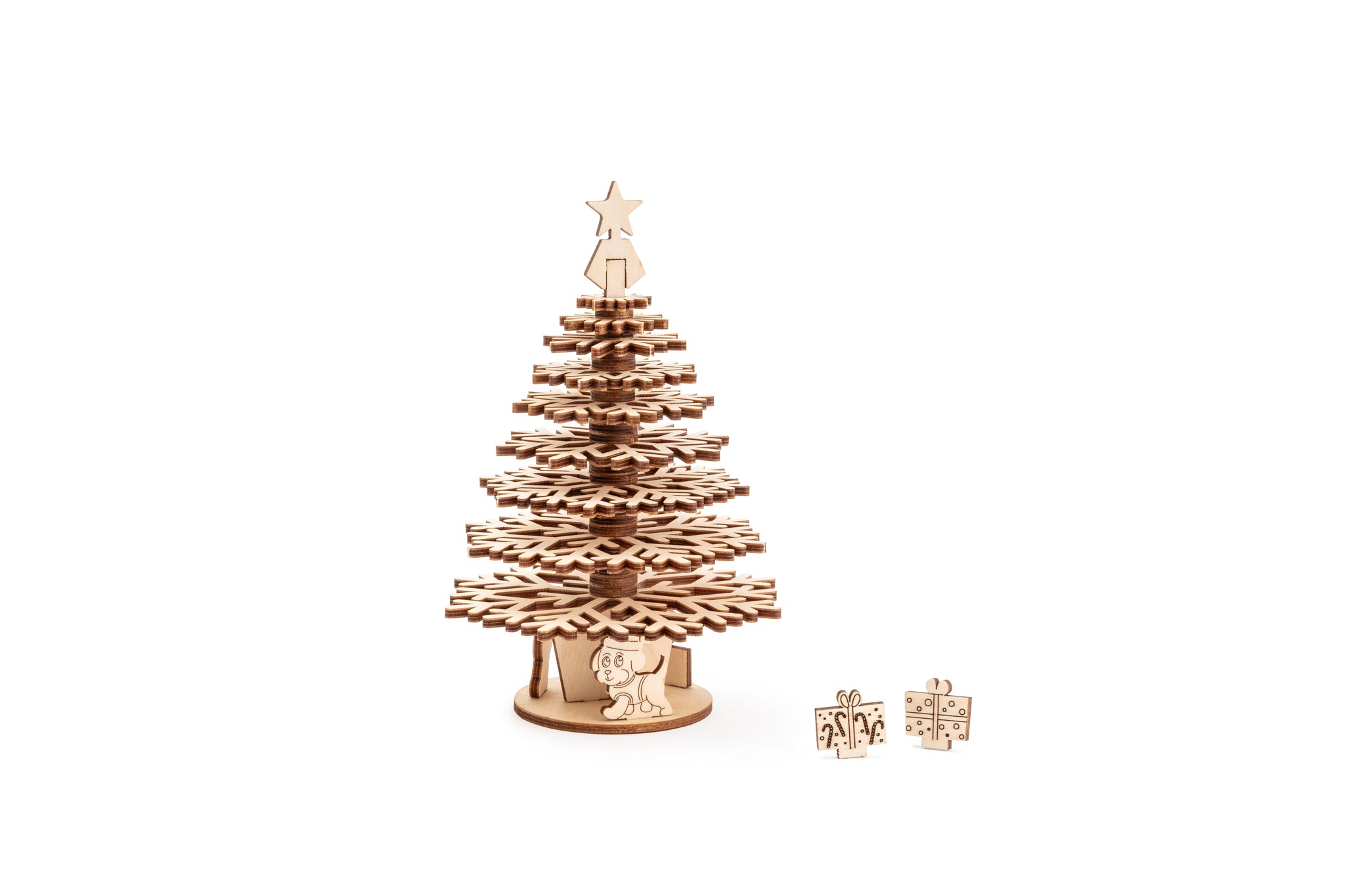 Medium height single laser-cut wooden Christmas tree with tiered snowflake shaped branches, featuring a white star finial topper and miniature  gift box and dog decorations at the base